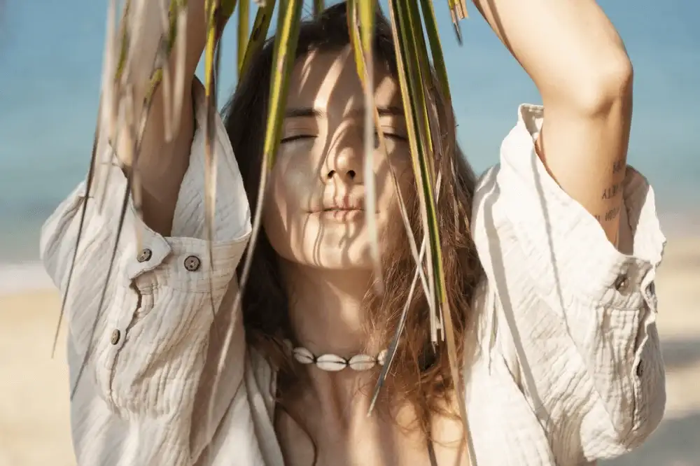 Girl in the sun under a palm tree