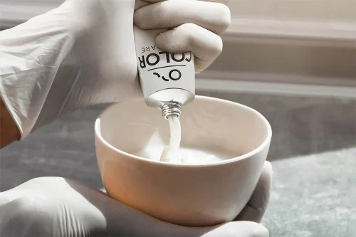 squeezing a tube of organic hair colour.